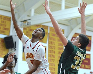 Jeff Lange | The Vindicator  FRI, FEB 5, 2016 - Mooney's Trell Thomas (center) looks to the basket for two between Ursuline's Anthony Howell (5) and Armon Nasseri (33) in the second half of their game at Mooney High School on Friday.