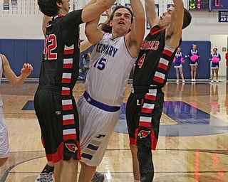 Poland's Nick Buccieri (15) goes in for a layup while being defended by Canfield's Sam Digiacomo (42) and Brandon McFall (4) during the first quarter of Friday nights matchup at Poland High School.  Dustin Livesay  |  The Vindicator  2/12/16  Poland.