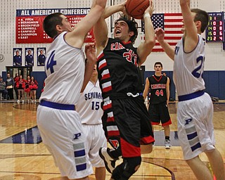 Canfield's Vince Ferrier (31) goes up for a layup but is closely defended by Poland's Jacon Burns (14) and Jared Burkhert during the second quarter of Friday nights matchup at Poland High School.  Dustin Livesay  |  The Vindicator  2/12/16  Poland.