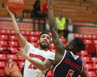 William D Lewis The Vindicator YSU's Francisco santiago(23) scores over UIC's Michael Kolawole(5).