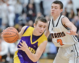 Jeff Lange | The Vindicator  FRI, FEB 19 2016 - Champion's Lucas Masonti (left) drives to the basket past Mineral Ridge's Christian DiRamos in the third quarter of their basketball game at Mineral Ridge High School on Friday.
