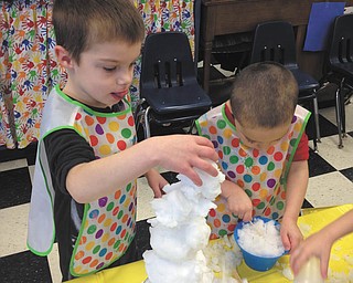 SPECIAL TO THE VINDICATOR | The students of Barb Conti’s enrichment class at Ursuline Preschool and Kindergarten brought the outdoors into the classroom as they played with snow. Eddie Johnson, left, and Nico Modarelli built snow towers during the event. Other students built snowmen and ice pops.