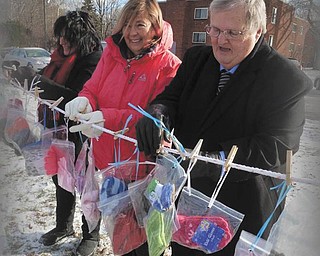 SPECIAL TO THE VINDICATOR | The GFWC Ohio Warren Junior Women’s League members recently collected and bagged scarves, hats and gloves for those in need for a Warming the Hearts of Trumbull County with Scarves of Love project. The members displayed bags of the winter gear, free to anyone that needs them, on a giving tree at the Niles Greenway bike trailhead with the participation of Niles mayor Thomas Scarnecchia and service director James Depasquale. Hanging some of the 200 items collected for the project were chairman Jonnah Hetzel, left, WJWL president Mary Lou Jarrett and Scarnecchia.