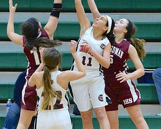 Jeff Lange | The Vindicator  MON, FEB 22, 2016 - Canfield's Ashley Kaleel (11) jumps for a rebound against Boardman's Krista Johnson (left) and Jenna Vivo (right) in the second quarter of their sectional semi final game at Akron St. Vincent St. Mary High School