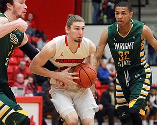 William D Lewis The Vindicator  YSU's Jordan Andrews(25 drives between WSU's Michael Karena(14) and Joe Thomasson(32) during2-25-16 game at YSU