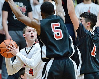 Jeff Lange | The Vindicator  FRI, FEB 26, 2016 - Canfield's Brandon McFall (4) searches for a teammate through a wall of Girard players in the fourth quarter of a basketball game in Canfield Friday night.