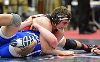 Trey Ellis of Canfield attempts to pin the shoulders of Jacob Esarco of Poland to the mat unsuccessfully during their 220lb Division II championship bout Saturday night at Alliance High School. SPECIAL TO THE VINDICATOR