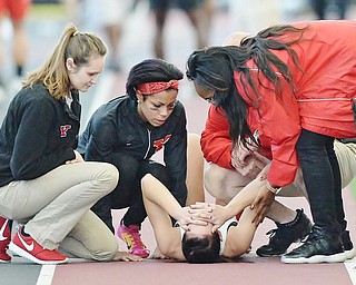 Jeff Lange | The Vindicator  SUN, FEB 28, 2016 - YSU's Jen Shiley (bottom) is surrounded by teammates after suffering an injury during the women's 400 meter run at the Horizon League Indoor Track Championship in Youngstown.