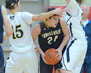 Jeff Lange | The Vindicator  MON, FEB 29, 2016 - Lowellville's Cole Beatty (center) attempts to get through two McDonald players, Jake Reckard (left) and Matt Howard (right) during their district semifinal game in Struthers on Monday.