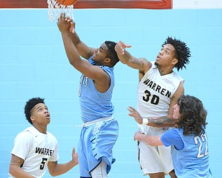 Jeff Lange | The Vindicator  WED, MAR 2, 2016 - Warren Harding's Kahmaree Bush (5) and Lynn Bowden (30) knock the ball out of the hands of Louisville's Rahul Young (center) as Jared Holland (22) looks on during first half action of their DI district semifinal in Alliance on Wednesday.