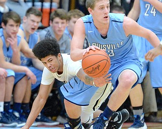 Jeff Lange | The Vindicator  WED, MAR 2, 2016 - Warren G. Harding's Tiryn Frank (left) stretches out in attempt to steal the ball away from Louisville's Chris Libertore in the third quarter of their DI district semifinal in Alliance on Wednesday.
