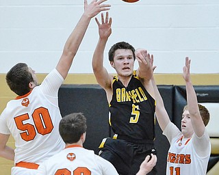 Jeff Lange | The Vindicator  FRI, MAR 4, 2016 - Garrettsville Garfield's Tommy Bissler (5) makes a leaping pass over Newton Falls' Ben Simpson (50), Alan boone (23) and Joey Urso (11) in the second half of their DIII district championship Friday night in Warren.