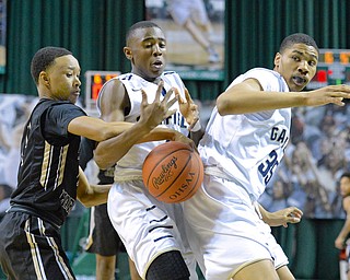 Jeff Lange | The Vindicator  WED, MAR 9, 2016 - Wrren Harding's Gabe Simpson (left) knocks the ball out of the hands of Garfield Height's Marreon Jackson (center) as Daejohn Bey looks on from the right during first quarter action of their Division I regional semifinal held at the Wolstein Center on the campus of Cleveland State University on Wednesday. Garfield Heights defeated Harding 49-43.