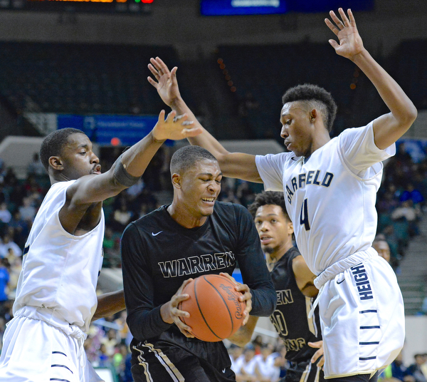 Jeff Lange | The Vindicator  WED, MAR 9, 2016 - Harding junior Derek Culver (center) struggles to maintain possession of the ball under the pressure of Garfield Heights' Willie Jackson (left) and Frankie Hughes (right) in the third quarter of Wednesday's Division I regional semifinal held at the Wolstein Center in Cleveland.