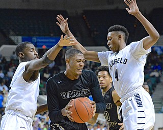 Jeff Lange | The Vindicator  WED, MAR 9, 2016 - Harding junior Derek Culver (center) struggles to maintain possession of the ball under the pressure of Garfield Heights' Willie Jackson (left) and Frankie Hughes (right) in the third quarter of Wednesday's Division I regional semifinal held at the Wolstein Center in Cleveland.
