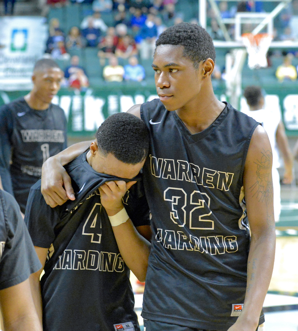 Jeff Lange | The Vindicator  WED, MAR 9, 2016 - Warren Harding's Javeonyae Artis (32) consoles teammate Gabe Simpson (4) after the Raiders' 49-43 loss to Garfield Heights in a Division I regional semifinal held at the Wolstein Center in Cleveland on Wednesday.