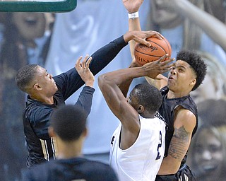 Jeff Lange | The Vindicator  WED, MAR 9, 2016 - Raiders' Derek Culver (left) and Kahmaree Bush (right) block the shot of Garfield Height's Willie Jackson in the second quarter of their Division I regional semifinal at the Wolstein Center in Cleveland on Wednesday.