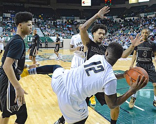 Jeff Lange | The Vindicator  WED, MAR 9, 2016 - Garfield Heights' Shawn Christian (12) falls out of bounds as he searches for an open teammate past Harding's Tiryn Frank (left), Lynn Bowden (center) and Gabe Simpson (right) in the final moments of their Division I regional semifinal held at the Wolstein Center in Cleveland on Wednesday. Harding fell to the Bulldogs 49-43.