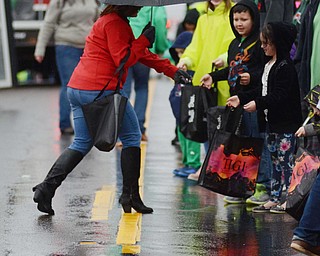 Katie Rickman | The Vindicator.A woman passes out candy to excited children along the parade route during the St. Patricks Day Parade in Boardman on Sunday afternoon. Despite rain and cooler temperatures many lines the streets for the annual parade.