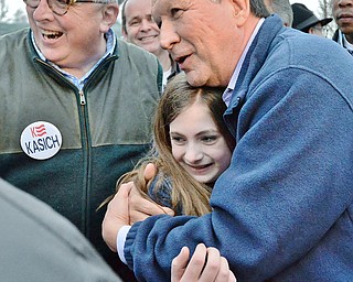 Jeff Lange | The Vindicator  SUN, MAR 13, 2016 - Ohio Governor John Kasich (right) embraces twelve-year-old Gracie Johnson as her uncle, Chairman of the Republican Party of Columbiana County, David Johnson smiles after Kasich's presidential rally in Hanoverton Sunday night.