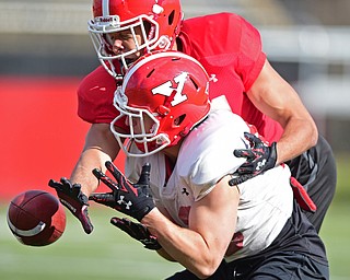 YOUNGSTOWN, OHIO - MARCH 18, 2016: Shane Dixon (red) knocks the ball away from Brad Good (white) during a 7 on 7 passing drill during the teams practice Friday afternoon at Stambaugh Stadium. DAVID DERMER | THE VINDICATOR