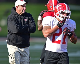 YOUNGSTOWN, OHIO - MARCH 18, 2016: Head coach Bo Pelini of YSU walks on the field in-between drills during the teams practice Friday afternoon at Stambaugh Stadium. DAVID DERMER | THE VINDICATOR