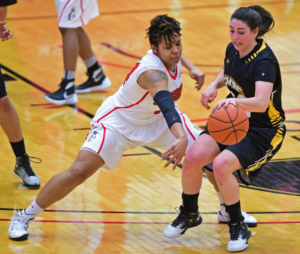 YOUNGSTOWN, OHIO - MARCH 19, 2016: Janae Jackson #44 of YSU swats at the basketball while Emily Russo #23 of UMBC guards against it during the 1st half of their game Saturday afternoon at Beeghly Center. YSU won 67-48. DAVID DERMER | THE VINDICATOR
