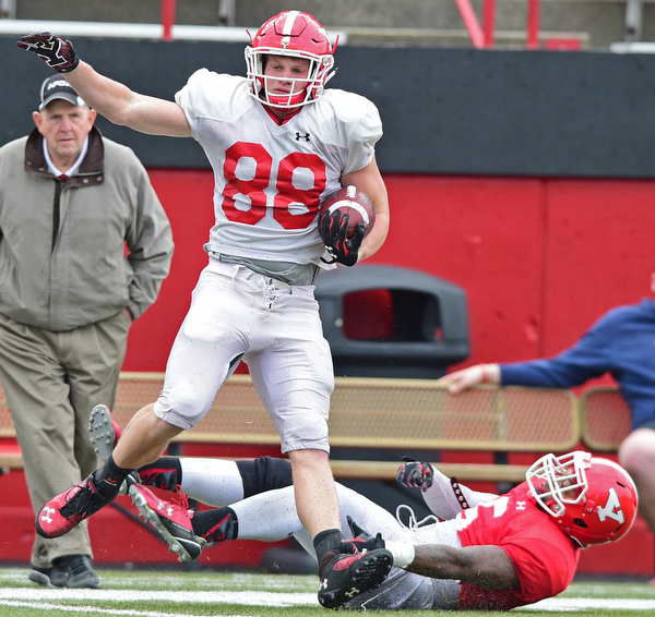 YOUNGSTOWN, OHIO - MARCH 23, 2016: Jacob Wood (white) spins away from Lee Wright (red) after catching the ball in the open field and breaking a tackle during the teams practice Wednesday afternoon at Stambaugh Stadium. DAVID DERMER | THE VINDICATOR