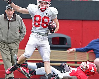 YOUNGSTOWN, OHIO - MARCH 23, 2016: Jacob Wood (white) spins away from Lee Wright (red) after catching the ball in the open field and breaking a tackle during the teams practice Wednesday afternoon at Stambaugh Stadium. DAVID DERMER | THE VINDICATOR
