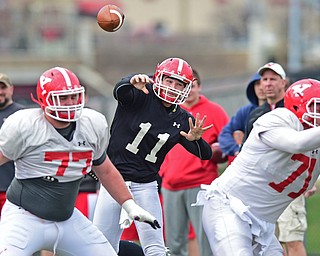 YOUNGSTOWN, OHIO - MARCH 23, 2016: Trent Hosick #11 of YSU throws a pass from the pocket while being protected by Dylan Colucci (left) and Cameron Fraser (right) during the teams practice Wednesday afternoon at Stambaugh Stadium. DAVID DERMER | THE VINDICATOR..