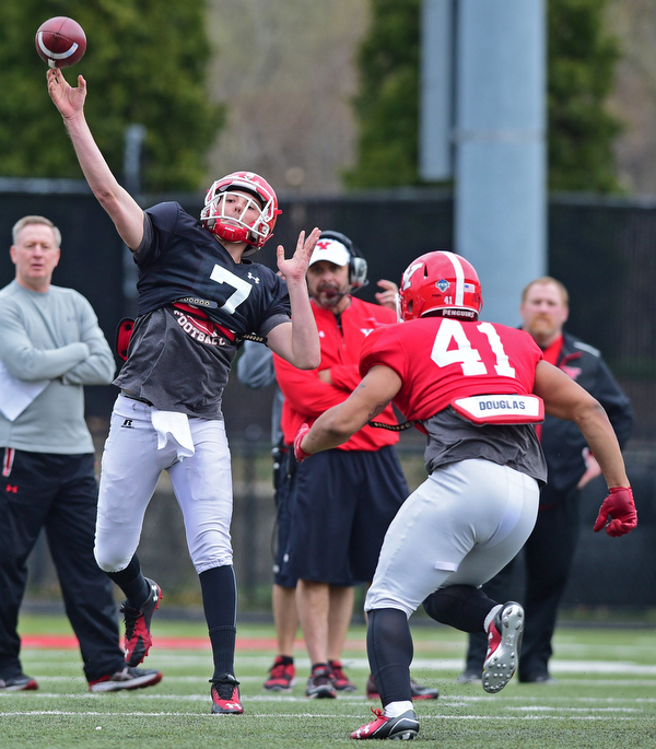 YOUNGSTOWN, OHIO - MARCH 23, 2016: Nathan Mays #7 of YSU throws a deep pass while avoiding pressure from Curtis Parks (red) during the teams practice Wednesday afternoon at Stambaugh Stadium. DAVID DERMER | THE VINDICATOR