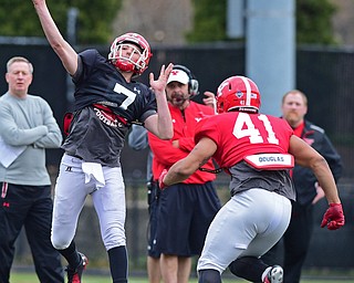 YOUNGSTOWN, OHIO - MARCH 23, 2016: Nathan Mays #7 of YSU throws a deep pass while avoiding pressure from Curtis Parks (red) during the teams practice Wednesday afternoon at Stambaugh Stadium. DAVID DERMER | THE VINDICATOR