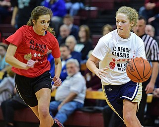 BOARD MAN, OHIO - MARCH 23, 2016: Autumn Kirila (white) of Brookfield drives down the lane while being pressured by Kaylee Manning (red) of West Branch during the Al Beach Classic Girls All-Star Basketball game Wednesday night at Boardman High School. DAVID DERMER | THE VINDICATOR