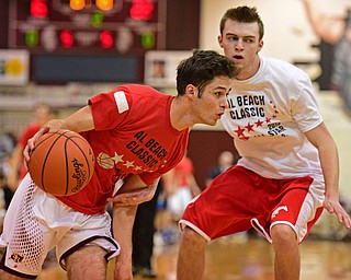 BOARD MAN, OHIO - MARCH 23, 2016: Preston Stitt (red) of South Range drives down the baseline while being pressured by Bryan Oatridge (white) of Mathews during the Al Beach Classic Boys All-Star Basketball game Wednesday night at Boardman High School. DAVID DERMER | THE VINDICATOR