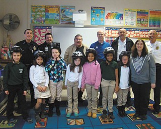 SPECIAL TO THE VINDICATOR | Second-grade students in Tricia Morgan’s class at St. Patrick School in Hubbard participated in the annual bicycle safety program hosted by the Hubbard Optimist Club. Hubbard City police officer Marcus Coonce and Hubbard Township police chief Todd Coonce also assisted in the program. It focused on the importance of the rules of the road for bicyclists, and the students learned how to use hand signals and to ride in areas without sidewalks. The students finished the course by taking a pledge to obey all safety rules while riding their bikes. Each student was given a new helmet, and told that if Hubbard City or Township officers see them following the rules as they ride their bikes, they will award the students with an ice cream coupon for the Hubbard Dairy Queen.  Program participants included, from the front row left, Nicholas Markulin, Lia Fiorini, Sara Lindholm, Ashley Lewis, Isabel Rodriguez, Rihannia Easterly, Aubrey Munnell, and Morgan. Those who volunteered to administer the program included Officer Coonce, back left, Chaplin Luke Oskin, Steve Pipic, Ray Wright, Tom Kilar and Chief Coonce. Nathan Kamraj also participated.