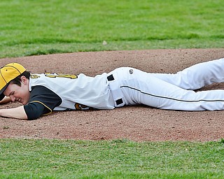 Jeff Lange | The Vindicator  WED, MAR 30, 2016 - Crestview's Dylan Dickey lies on the mound in pain after being hit by a line drive in the first inning of Crestview's game against Ursuline at Bob Cene Park in Struthers on Wednesday. Crestview fell to Ursuline, 2-0.
