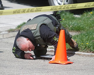      ROBERT K. YOSAY  | THE VINDICATOR..A member of the Task Force looks for shell casings .. on Maywood.."Members of the US Marshals Northern Ohio Violent Fugitive Task Force were actively searching for Luis R Cruz-Ramos," said Capt. Brad Blackburn in the news release. "He was spotted walking near the 200 block of Lowell Avenue. He fled toward Maywood, holding a handgun as the task force attempted to apprehend him." - .--30-...