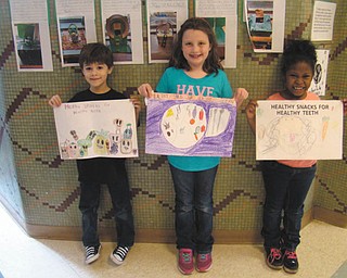 SPECIAL TO THE VINDICATOR | Bradyich Dental hosted its annual dental health poster contest for students in kindergarten through fourth grade at St. Patrick School in Hubbard in honor of February being Dental Health month. A dental health assistant from Bradyich Dental visited the school and gave a presentation to the students to explain the basics of dental health and also to introduce the contest and this year’s theme, “Healthy Snacks for Healthy Teeth.” The grand prize winner, third-grader Nicholas Maillis, left, won a Kindle Fire, and grade winners Sara Lindholm of second grade and LaTaya Hubbard of kindergarten received $25 gift cards to Toys R Us. Nora DePizzo of fourth grade also won a gift card.