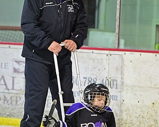 BOARDMAN, OHIO - APRIL 2, 2016: Joshua Kurth #6 of the Youngstown Boom plays the puck in the corner while being pushed by his father Josh Kurth during a Adaptive Sled Ice Hockey charity game against the Youngstown Phantoms Bantam A Team Saturday afternoon at the Ice Zone. DAVID DERMER | THE VINDICATOR