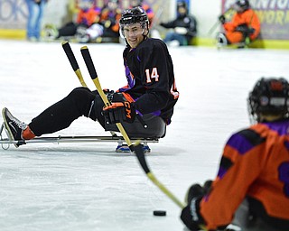 BOARDMAN, OHIO - APRIL 2, 2016: James Winkler #14 of the Phantoms skates ahead while playing a pass from Brian Woak #86 during a Adaptive Sled Ice Hockey charity game against the Youngstown Boom Saturday afternoon at the Ice Zone. DAVID DERMER | THE VINDICATOR