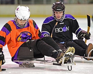 BOARDMAN, OHIO - APRIL 2, 2016: Geoffrey Bokor #14 of the Youngstown Phantoms Bantam A Team skates with the puck ahead of Jacob Hostetter #7 of the Youngstown Boom during a Adaptive Sled Ice Hockey charity game against the Youngstown Boom Saturday afternoon at the Ice Zone. DAVID DERMER | THE VINDICATOR