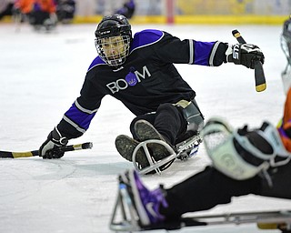 BOARDMAN, OHIO - APRIL 2, 2016: William Weaver #69 of the Youngstown Boom winds up before take a shot while goalie Sophie Bellina #29 of the Youngstown Phantoms Bantam A Team during a Adaptive Sled Ice Hockey charity game against the Youngstown Phantoms Bantam A Team Saturday afternoon at the Ice Zone. DAVID DERMER | THE VINDICATOR