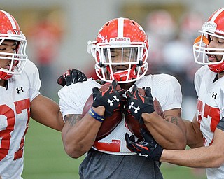 Jeff Lange | The Vindicator  SAT, APRIL 2, 2016 - YSU TB Roosevelt Griffin (center) rushes for yards as teammates Tevin McCaster (left) and Bryce Boyd attempt to knock the footballs from his hands during Saturday's practice in Youngstown.