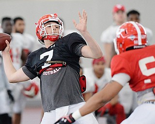 Jeff Lange | The Vindicator  SAT, APRIL 2, 2016 - YSU quarterback Nathan Mays (7) looks downfield over defensive lineman Shereif Bynum (50) during Saturday's practice in Youngstown.