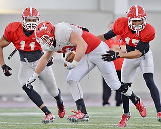 Jeff Lange | The Vindicator  SAT, APRIL 2, 2016 - YSU tight end Kevin Rader (center) is brought down after a reception by Derek Rivers (11) and Avery Larkin during practice in Youngstown Saturday morning.