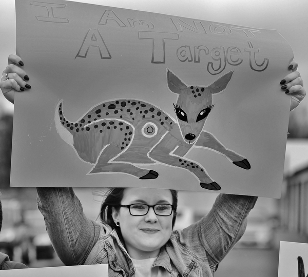 Jeff Lange | The Vindicator  MON, APRIL 4, 2016 - Ashley Molnar of Niles raises a sign above her head during a protest against the opening of Candywood Whitetail Ranch on Monday evening in Vienna. "I feel like they should be turning the land into a nature preserve. Breeding animals to kill them is not right," Molnar said.
