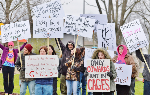 Jeff Lange | The Vindicator  MON, APRIL 4, 2016 - Animal rights activists gather with signs in hand to protest the opening of Candywood Whitetail Ranch in Vienna prior to the start of a town hall meeting in Vienna Township Monday evening.