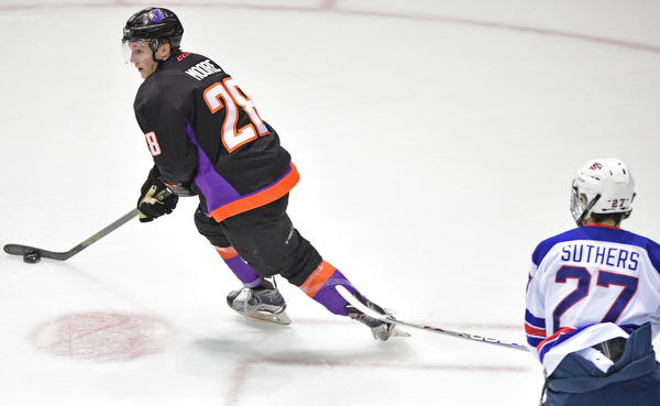 YOUNGSTOWN, OHIO - APRIL 9, 2016: Connor Moore #28 of the Phantoms skates with the puck while being trailed by Keenan Suthers #27 of Team USA during the first period of Saturday nights game at the Corelli Centre. DAVID DERMER | THE VINDICATOR