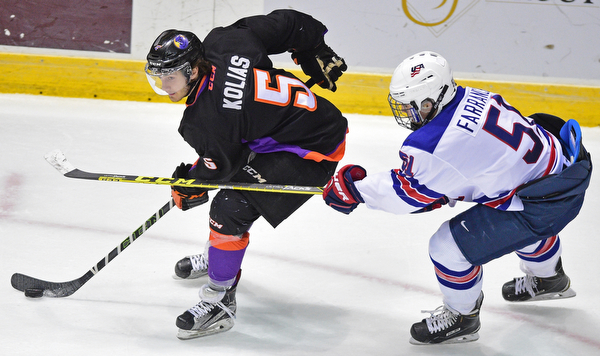 YOUNGSTOWN, OHIO - APRIL 9, 2016: Vas Kolas #5 of the Phantoms moves the puck up ice while being pressured from behind by David Farrance #51 of Team USA during the first period of Saturday nights game at the Corelli Centre. DAVID DERMER | THE VINDICATOR