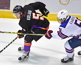 YOUNGSTOWN, OHIO - APRIL 9, 2016: Vas Kolas #5 of the Phantoms moves the puck up ice while being pressured from behind by David Farrance #51 of Team USA during the first period of Saturday nights game at the Corelli Centre. DAVID DERMER | THE VINDICATOR